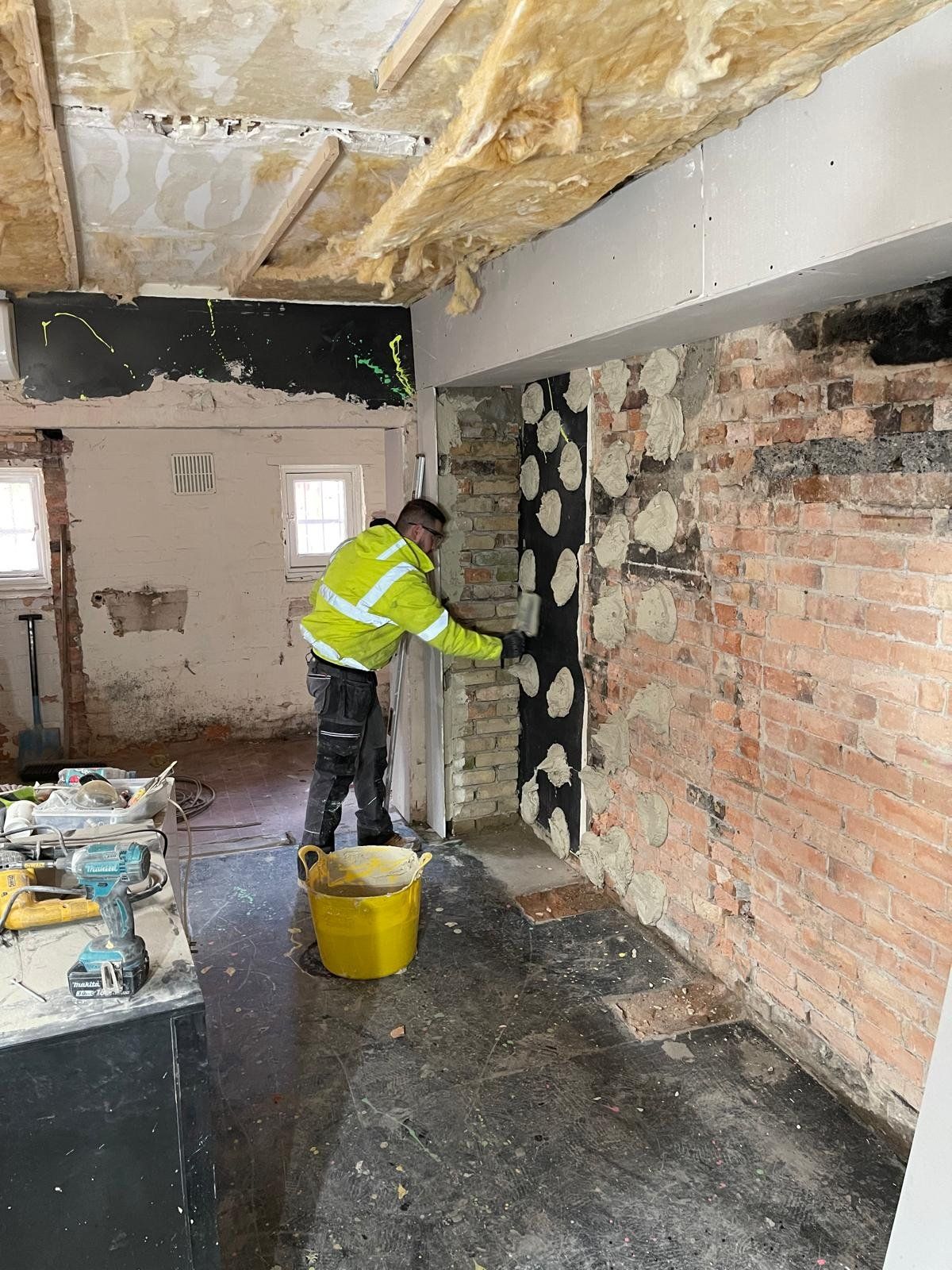 Builder repointing a brick wall