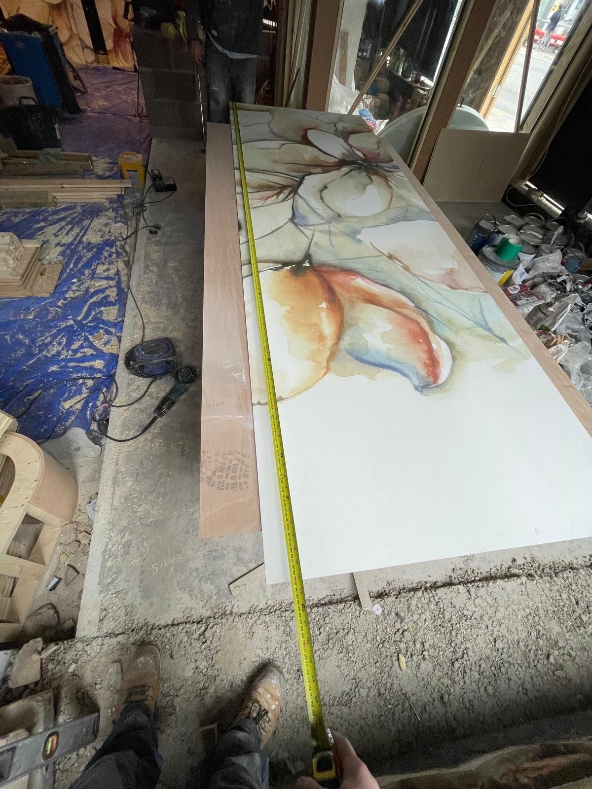 Mural being installed on a bar feature wall