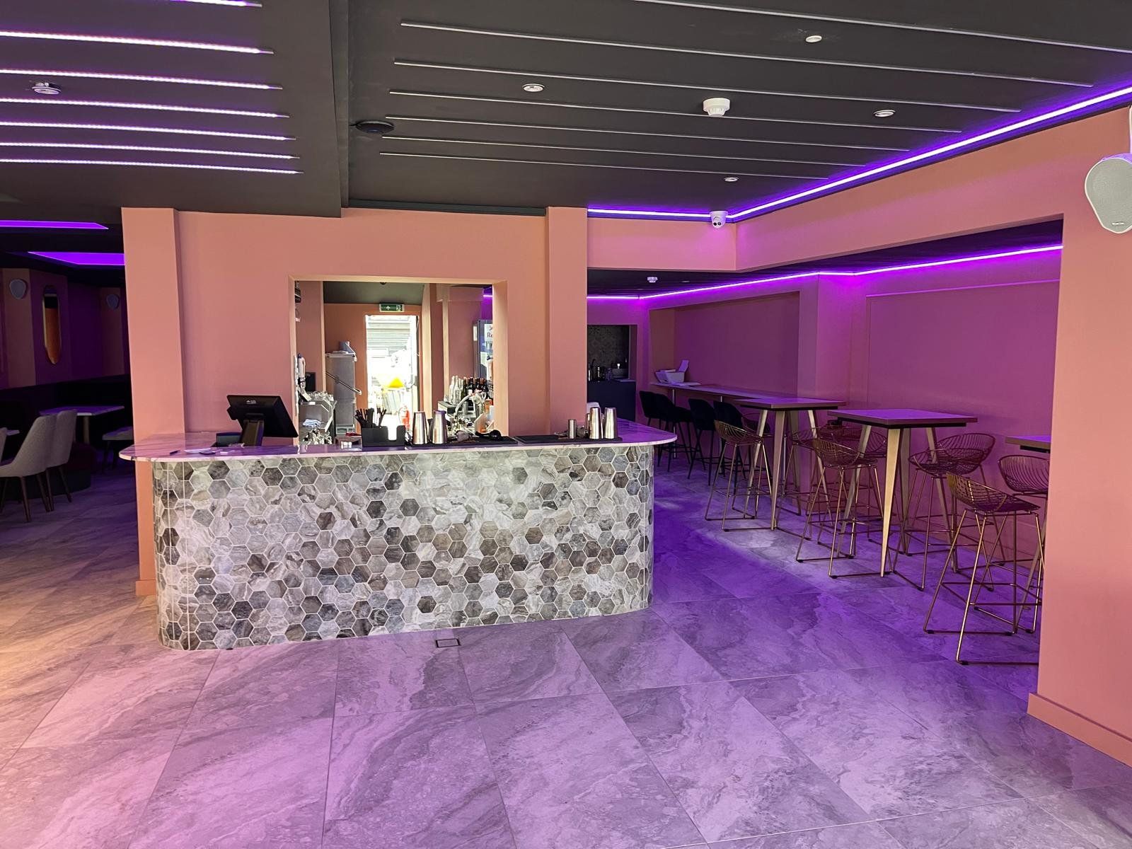 Bar counter with mosaic front and purple neon