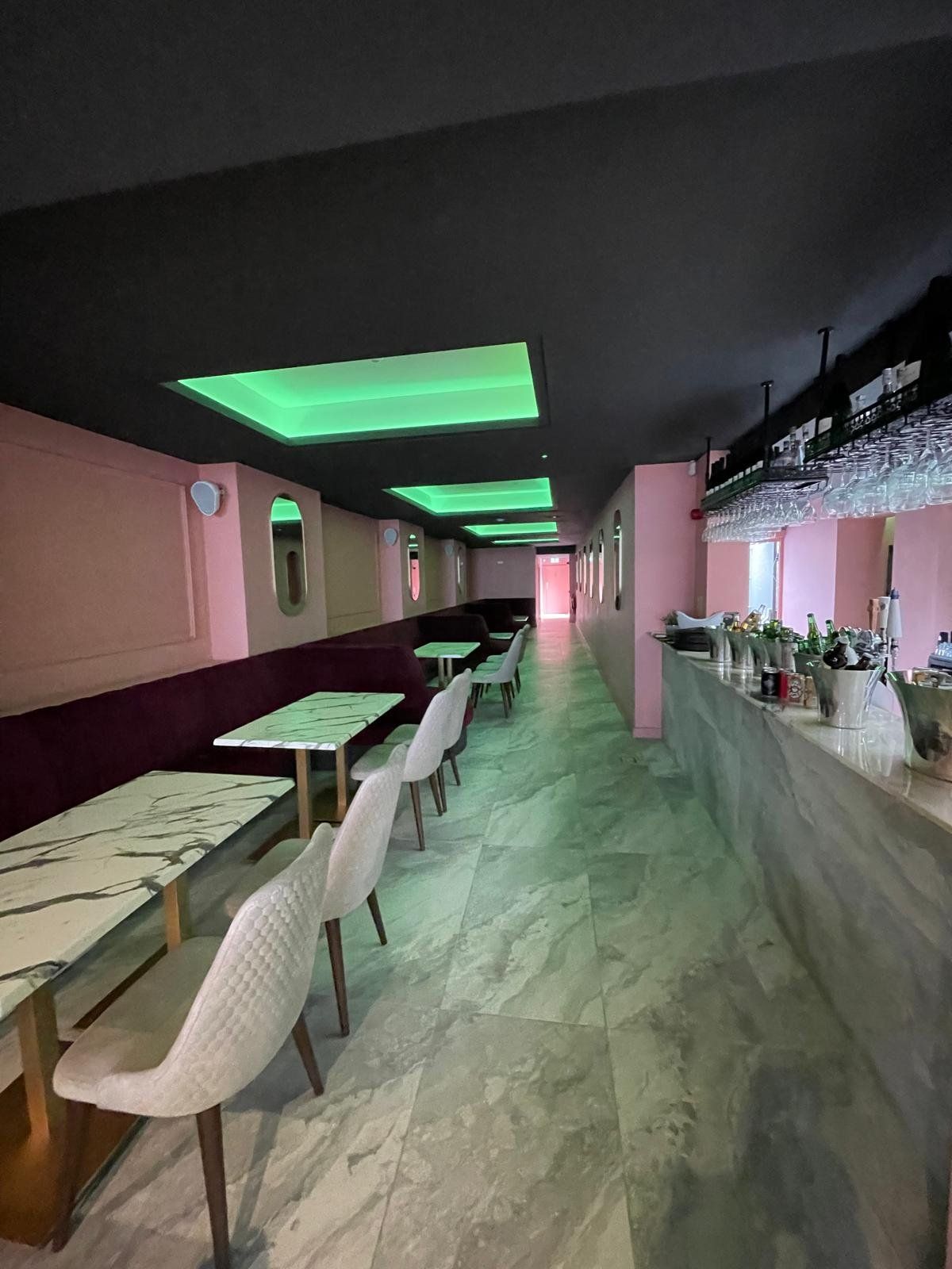 Restaurant area with marble tables and green neon
