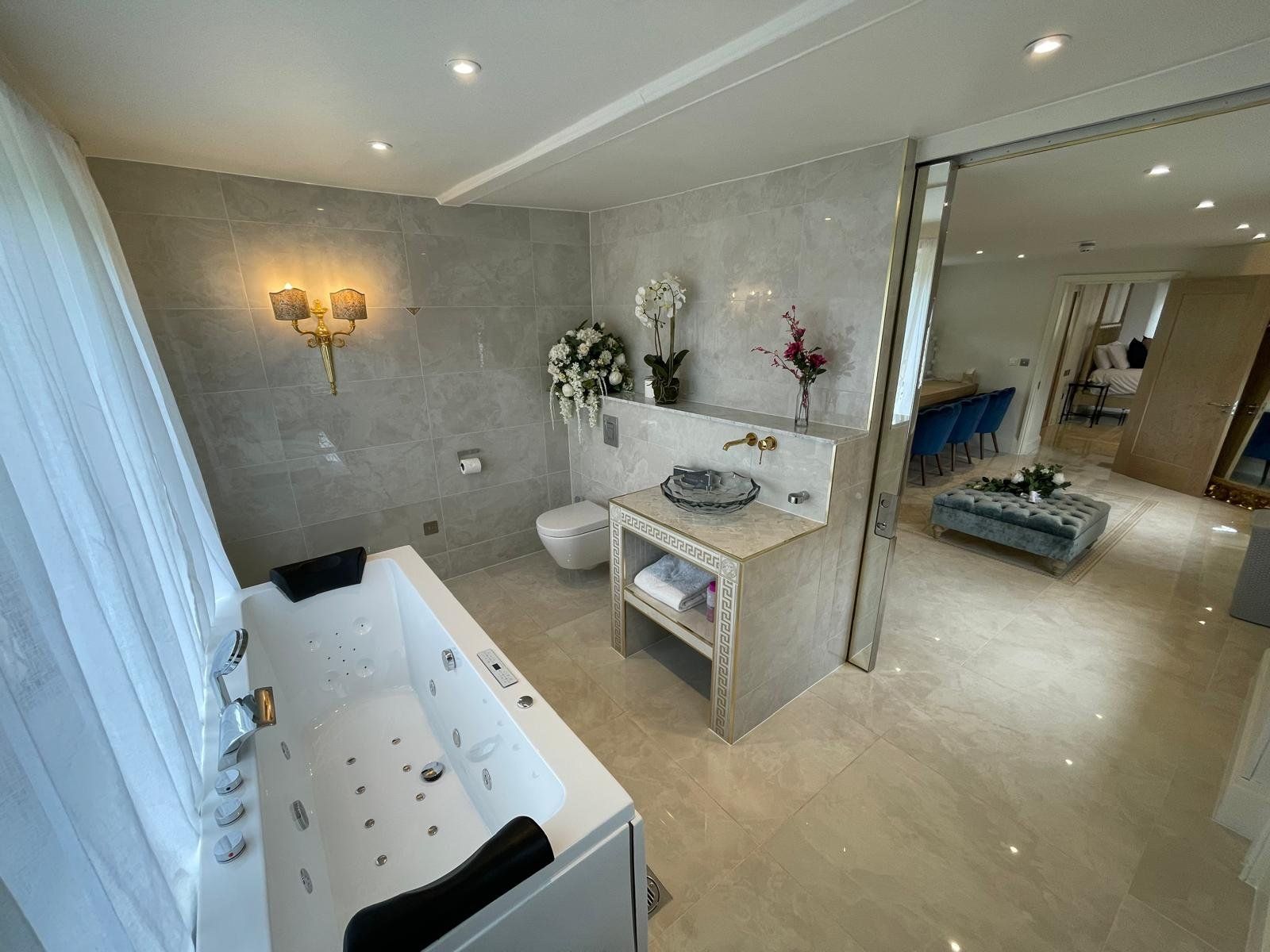Whirlpool bath with grey tiling