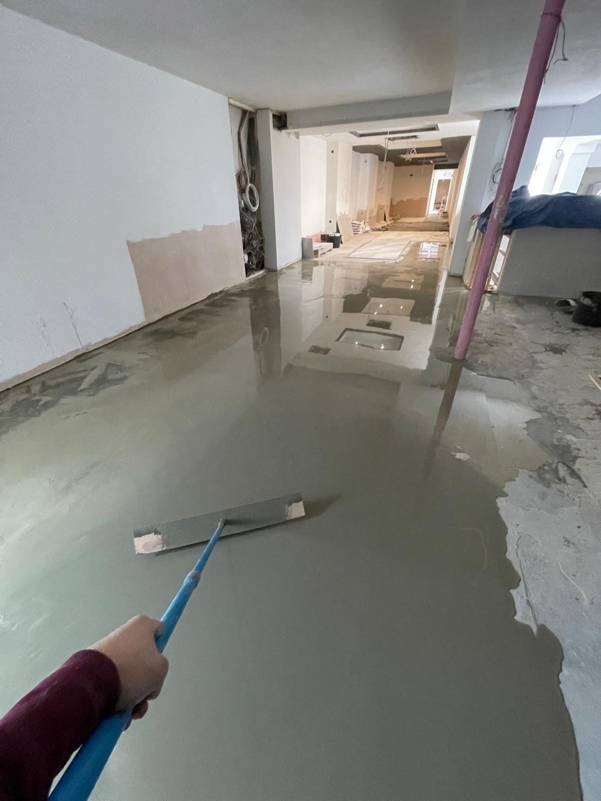 Self-levelling floor screed being laid