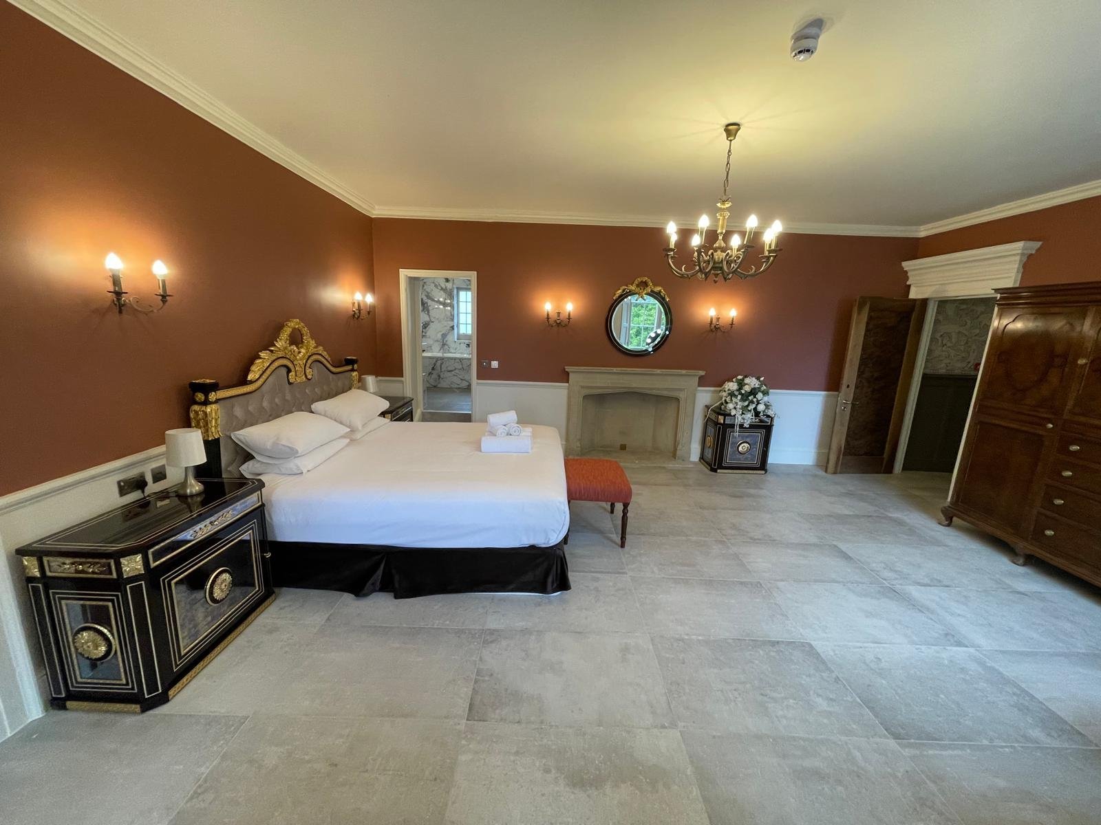 Luxury bedroom with stone fireplace after complete refurbishment in Oxfordshire