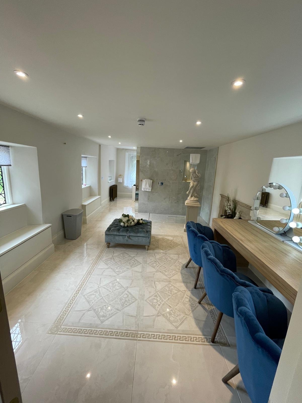 Refurbished period hallway with patterned marble floor and blue accent chairs in Oxford