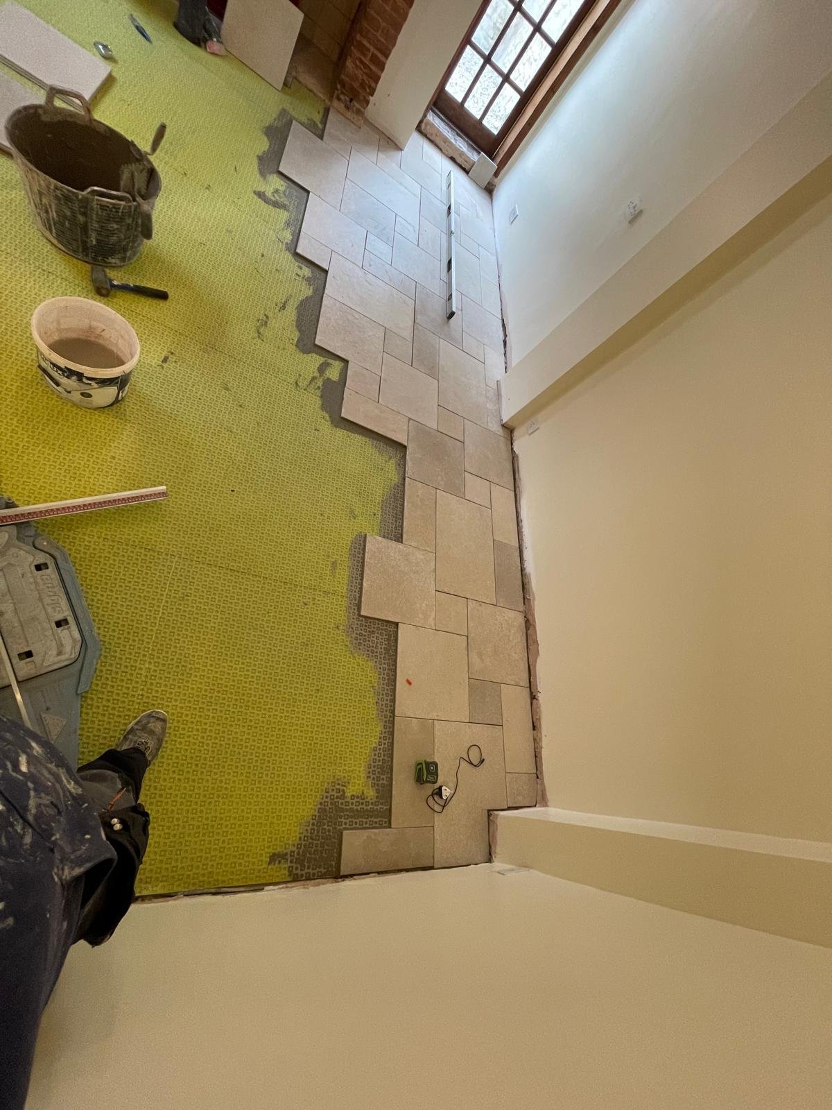 Large-format stone floor tiles being laid in period property in Oxford